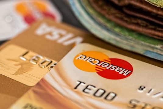 Mastercard and Visa credit cards next to a leather wallet, viewed from a close angle
